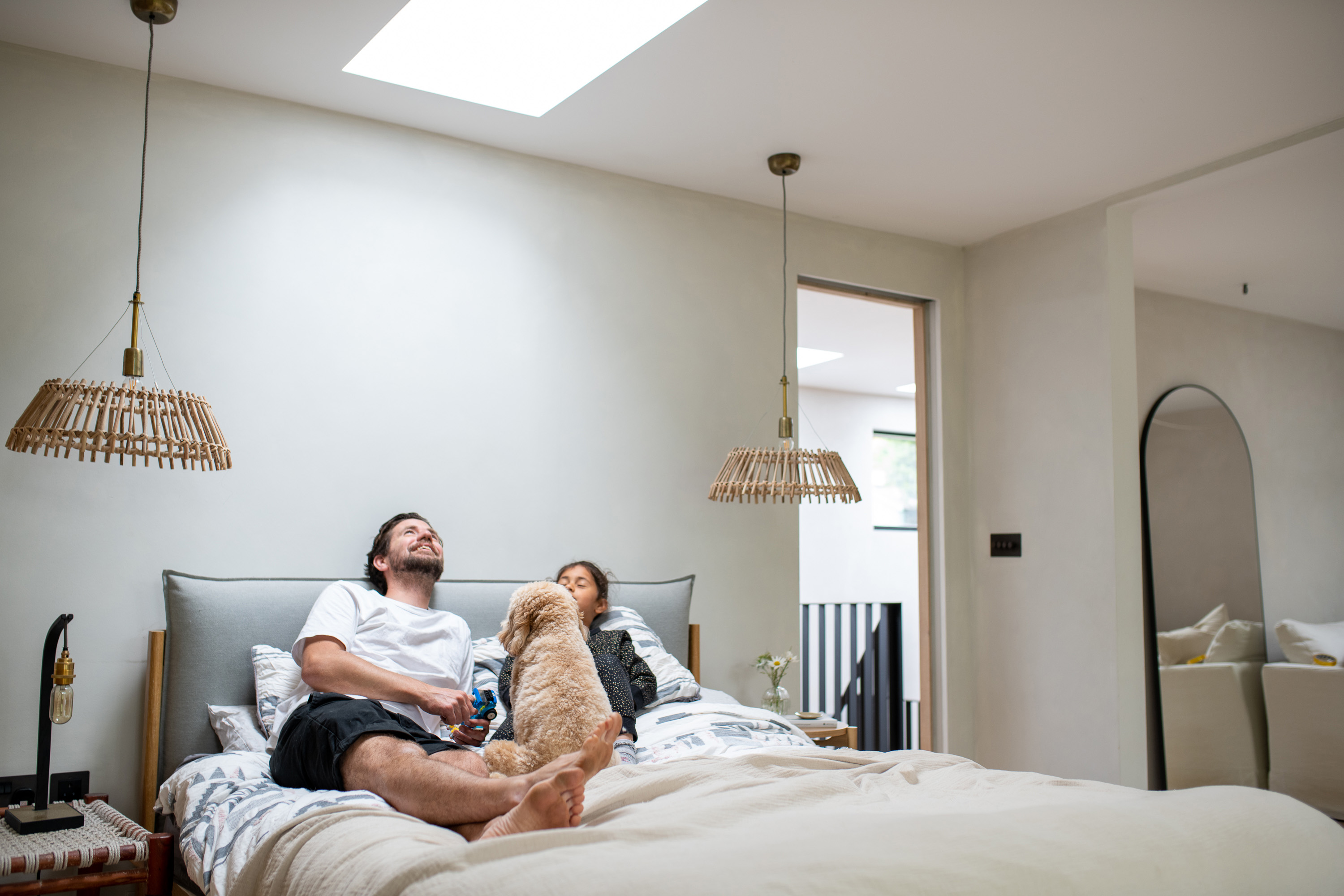 two people sitting on a bed looking up at a rooflight 